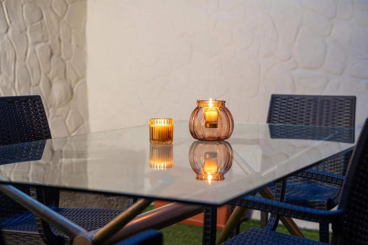 Candele accese sul tavolo di vetro del giardino