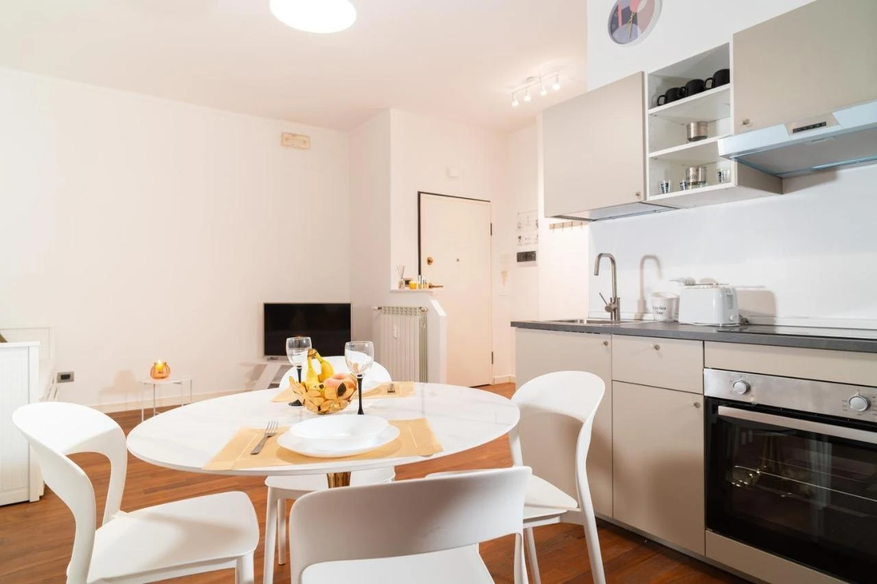 Cucina e tavolo rotondo con sedie bianche
